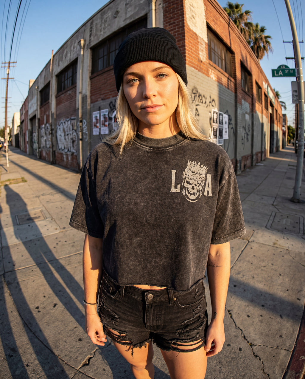 Woman wearing a black t-shirt hockey crop top with 'L.A.' print on a street in Los Angeles.