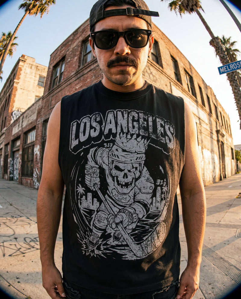 Person wearing a 'Los Angeles' sleeveless shirt with a skull design on a street with palm trees.