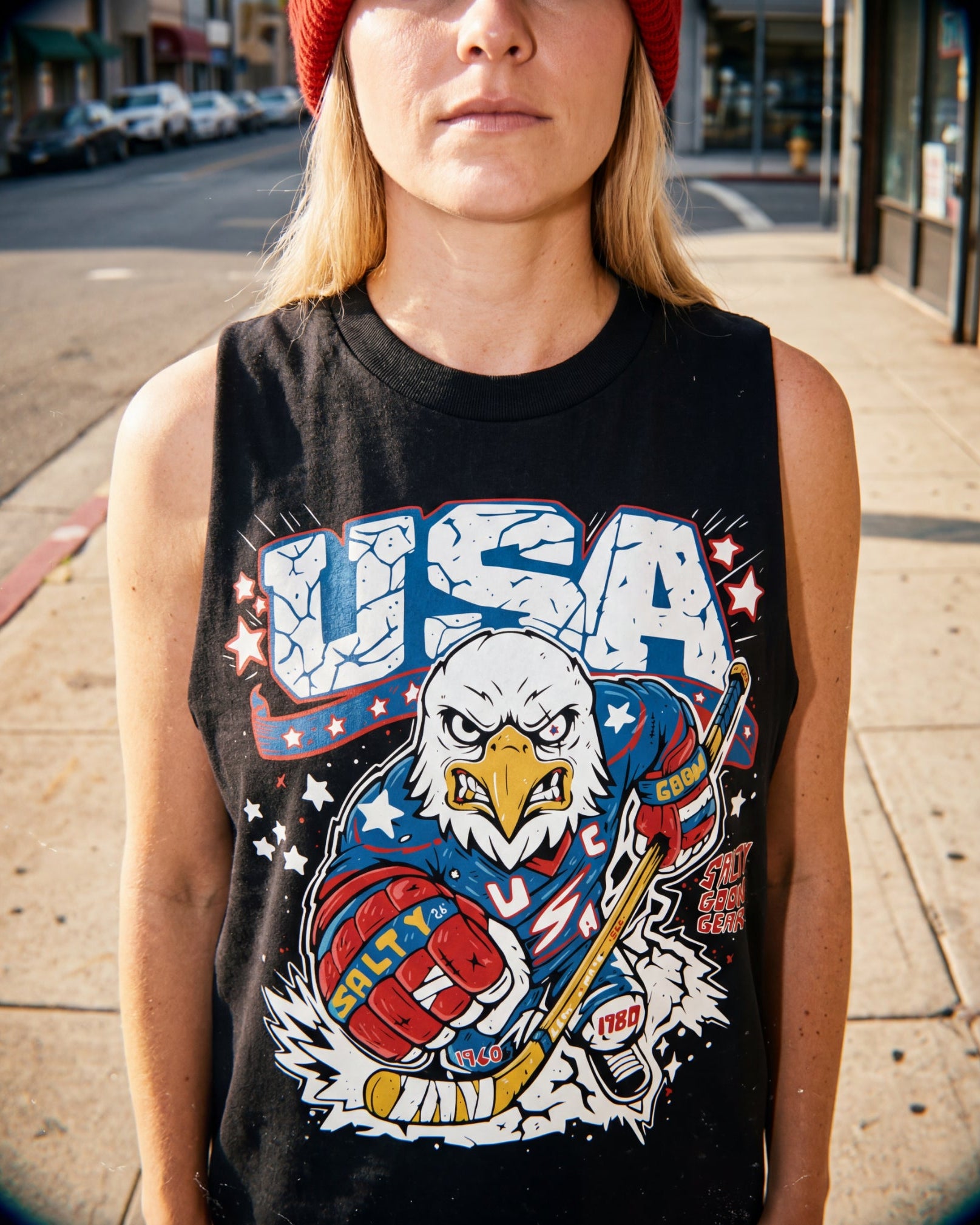 Person wearing a black tank top with a USA graphic design featuring an eagle.